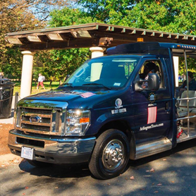 front angle view of an Arlington Cemetery Tours vehicle parked in front of a covered vehicle stop